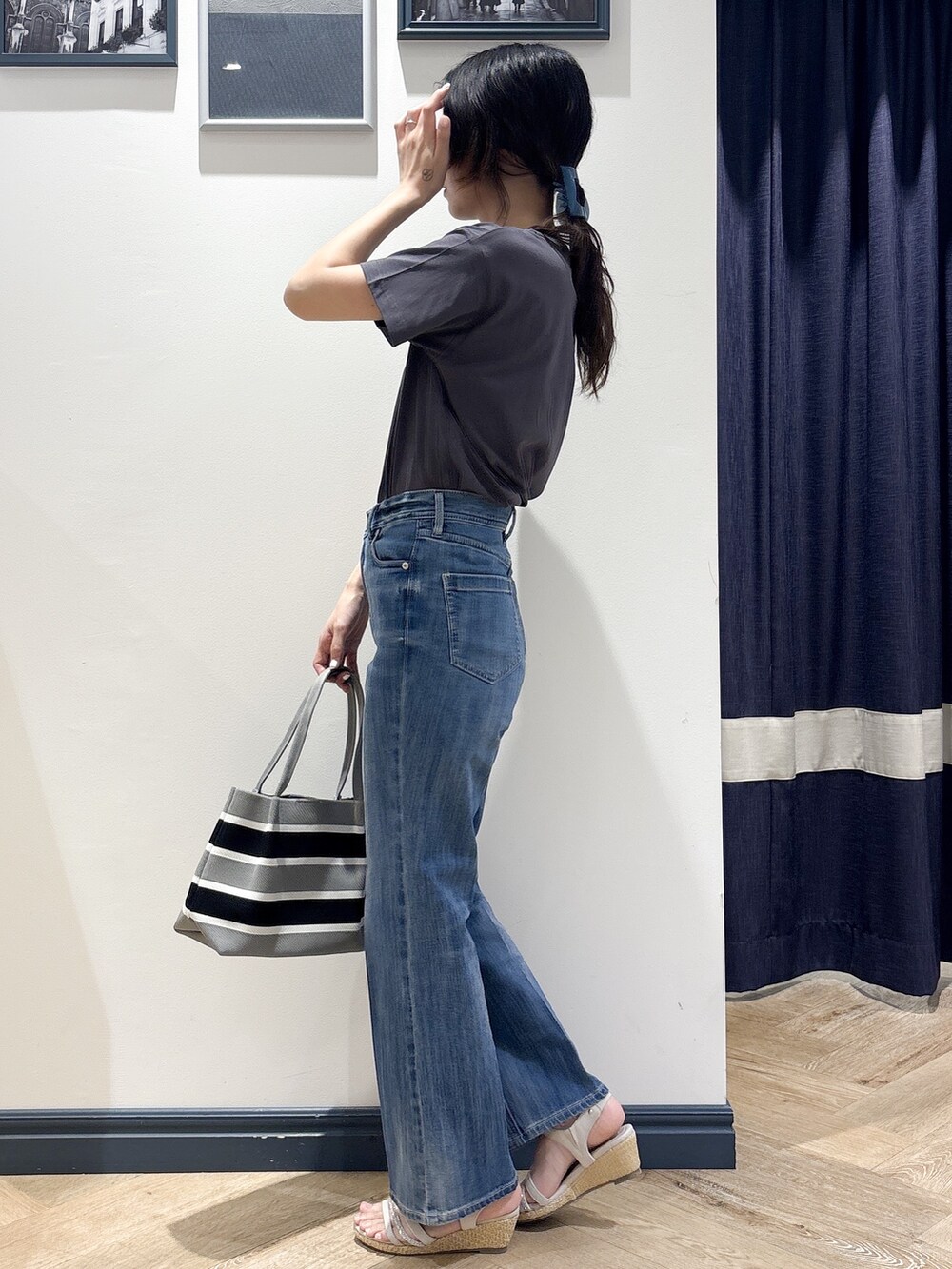 グレー系のTシャツ/カットソー、ブルー系のデニムパンツ、グレー系のトートバッグを着用したレディースの夏コーディネートの2枚目の写真