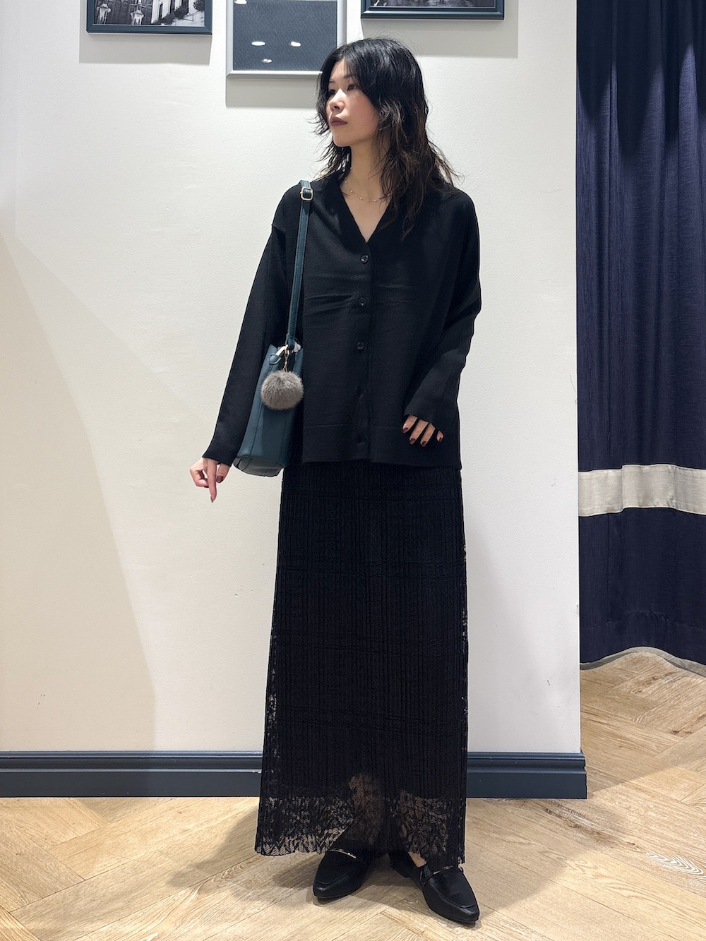 ブラック系のカーディガン/ボレロ、ブラック系のスカート、グリーン系のショルダーバッグを着用したレディースの秋コーディネートの2枚目の写真