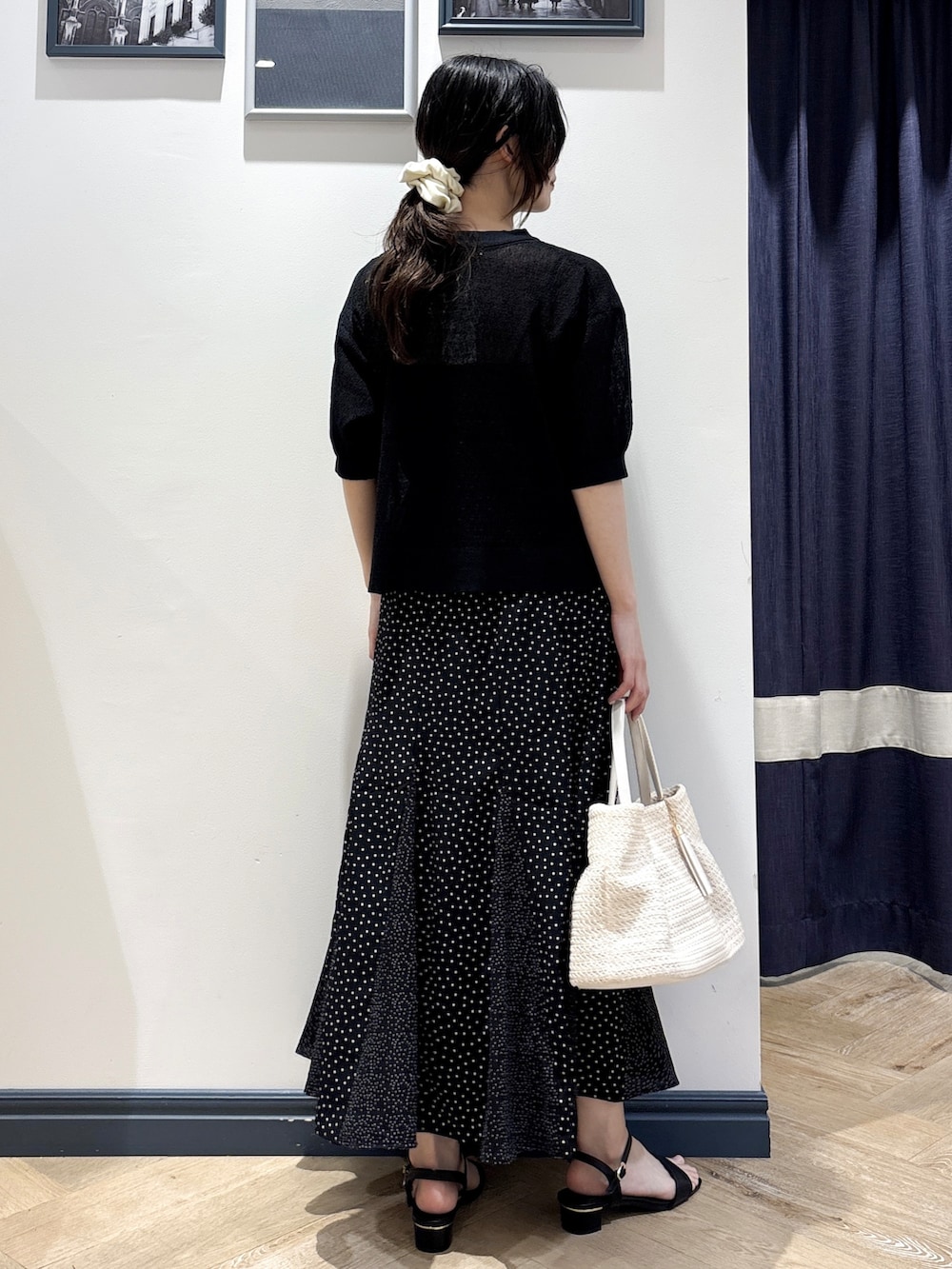 ブラック系のカーディガン/ボレロ、ブラック系のスカート、ホワイト系のトートバッグを着用したレディースの夏コーディネートの3枚目の写真