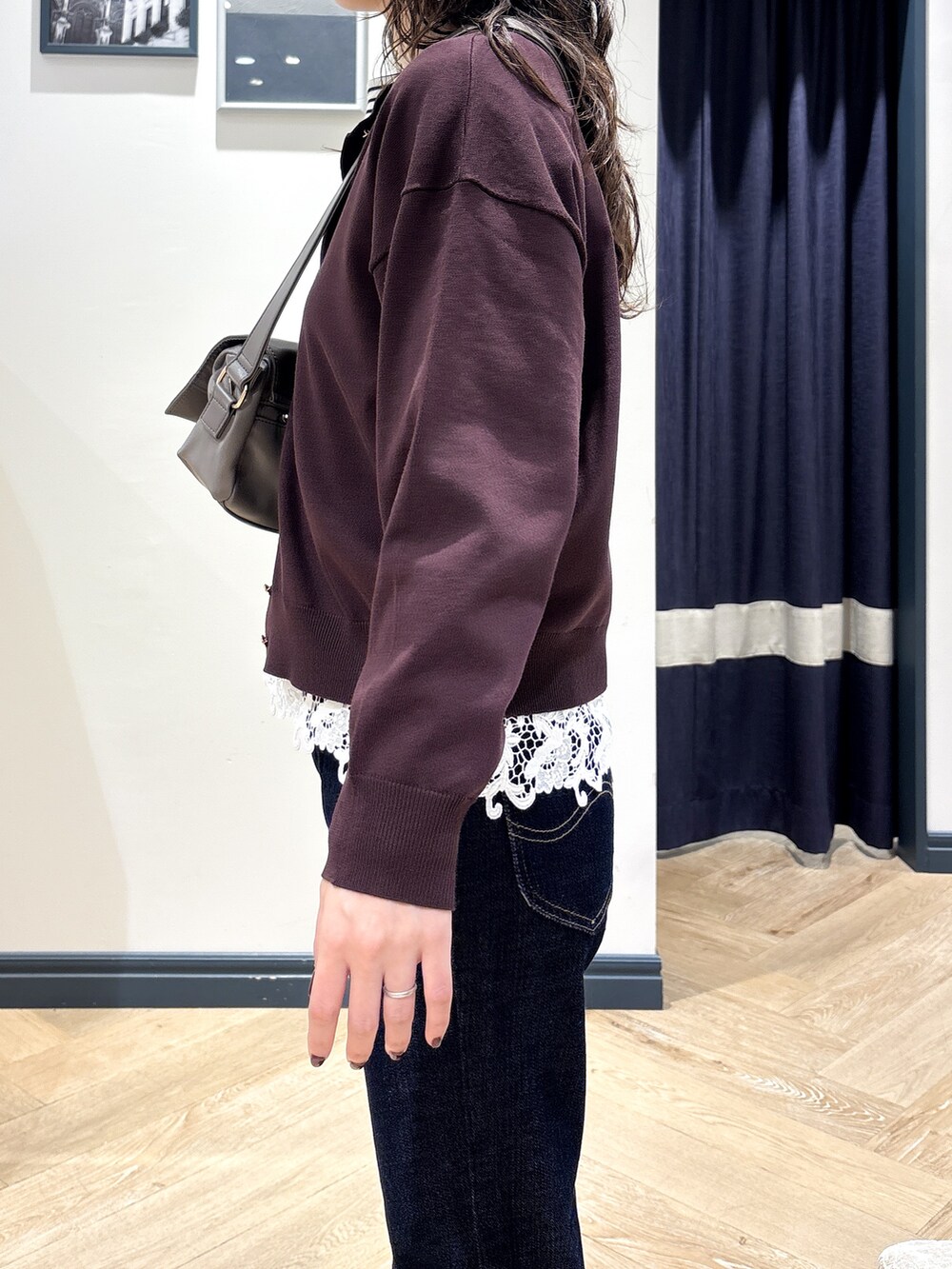 ブラウン系のカーディガン/ボレロ、ホワイト系のTシャツ/カットソー、ブルー系のデニムパンツを着用したレディースの秋コーディネートの5枚目の写真