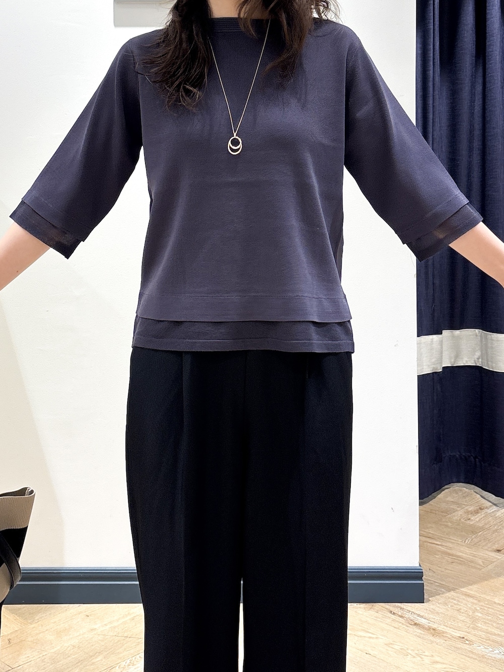 グレー系のニット/セーター、ブラック系のその他パンツ、ブラック系のトートバッグを着用したレディースの秋コーディネートの4枚目の写真
