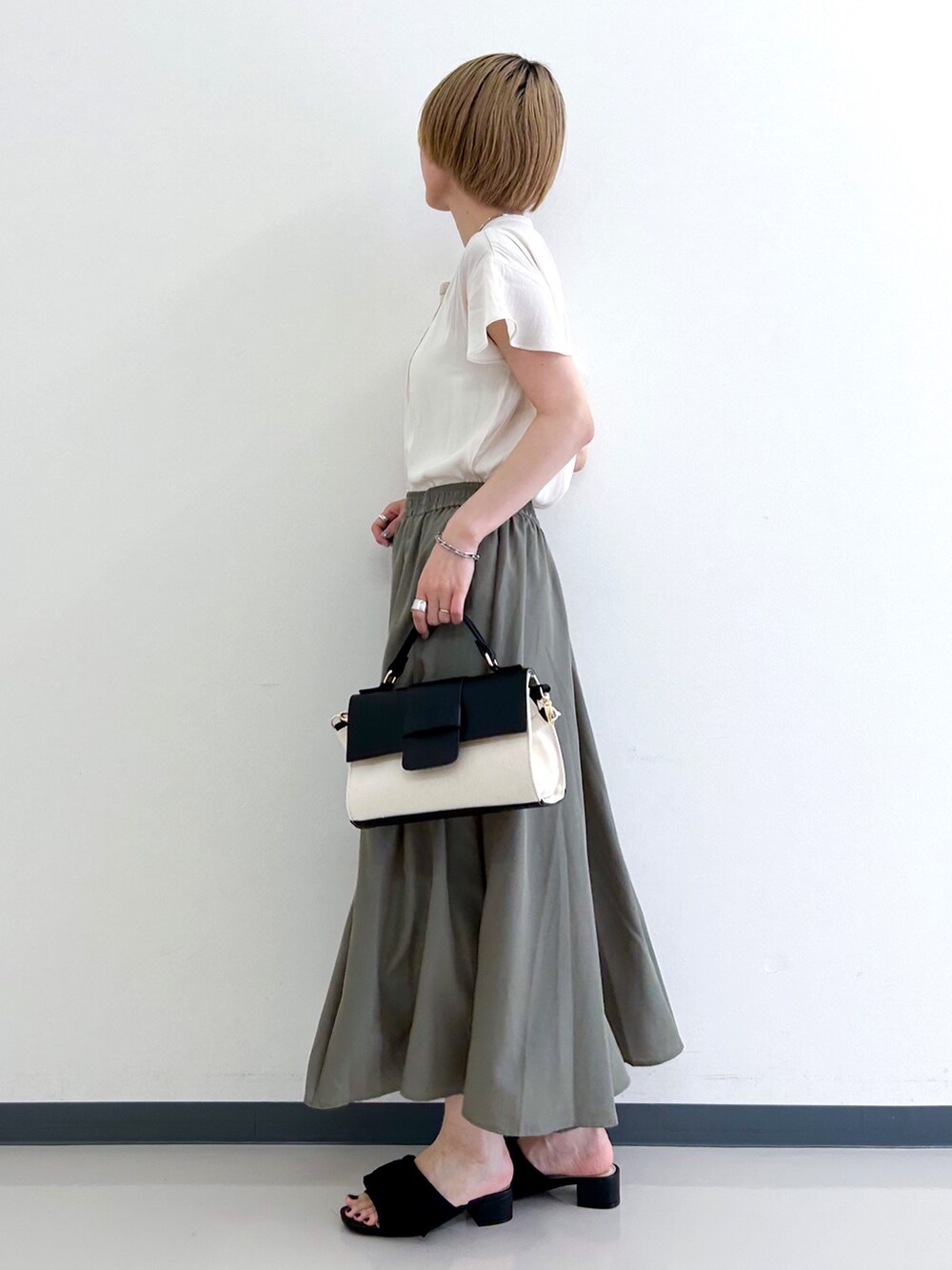 ホワイト系のシャツ/ブラウス、グリーン系のスカート、ブラック系のショルダーバッグを着用したレディースの春コーディネートの2枚目の写真