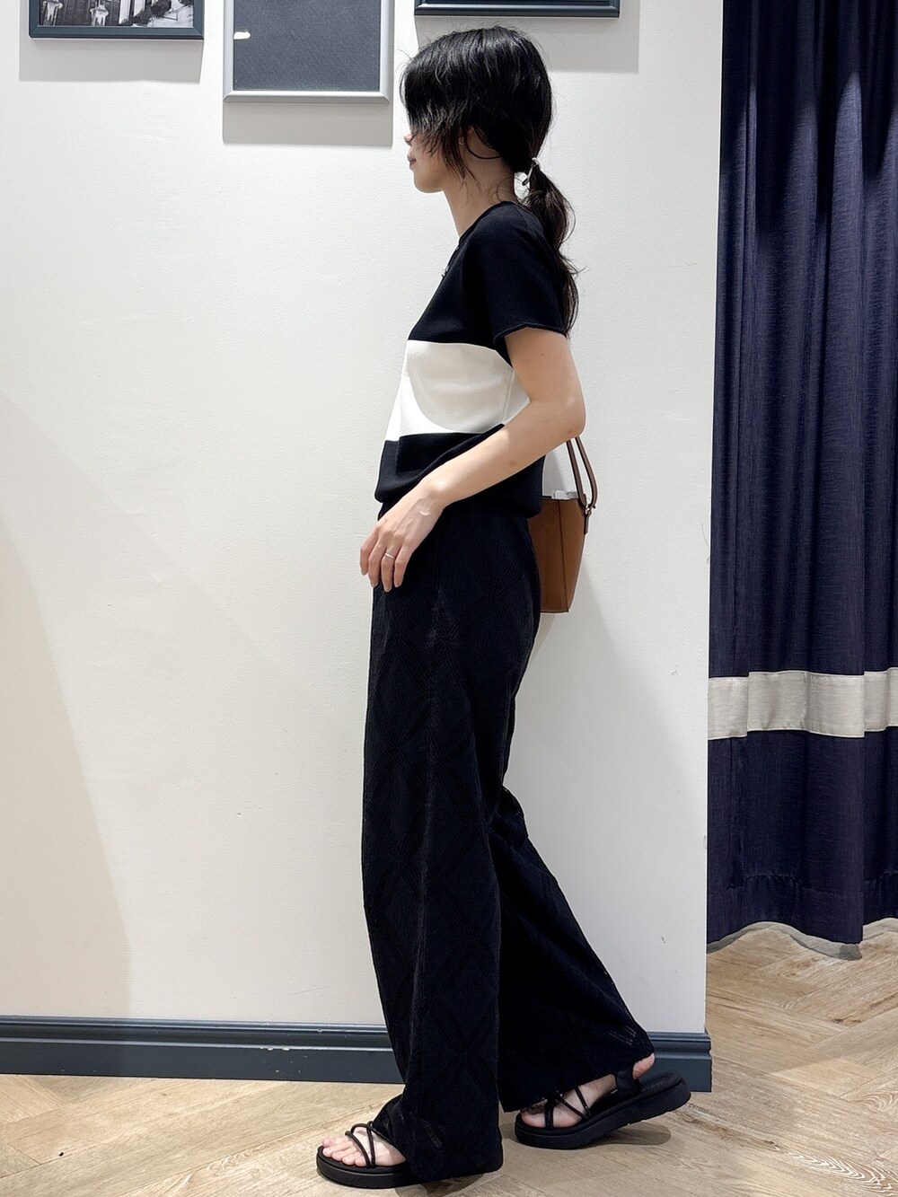 ブラック系のニット/セーター、ブラック系のその他パンツ、イエロー系のショルダーバッグを着用したレディースの春コーディネートの2枚目の写真