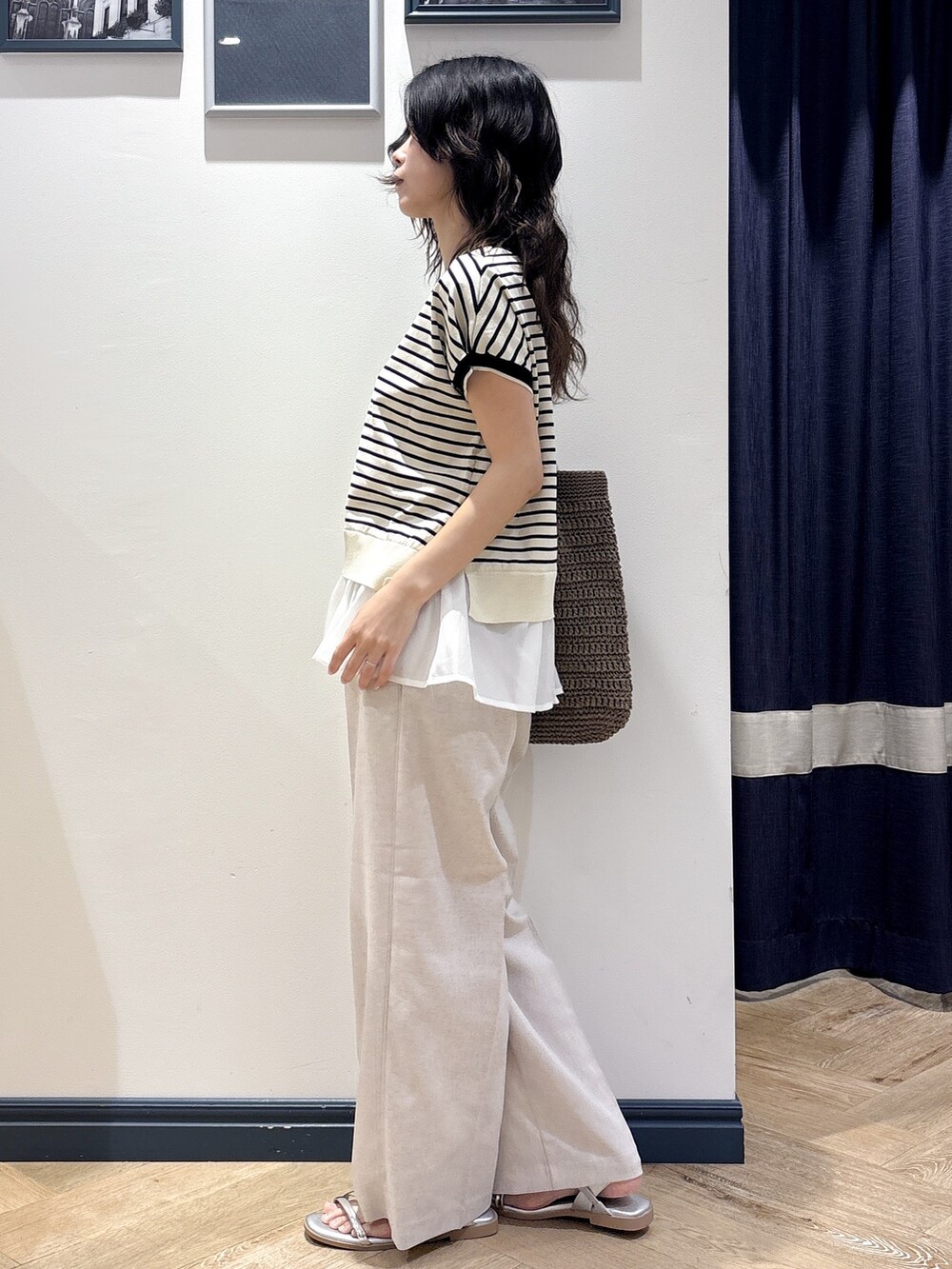 ホワイト系のニット/セーター、ベージュ系のその他パンツ、ブラウン系のトートバッグを着用したレディースの夏コーディネートの2枚目の写真
