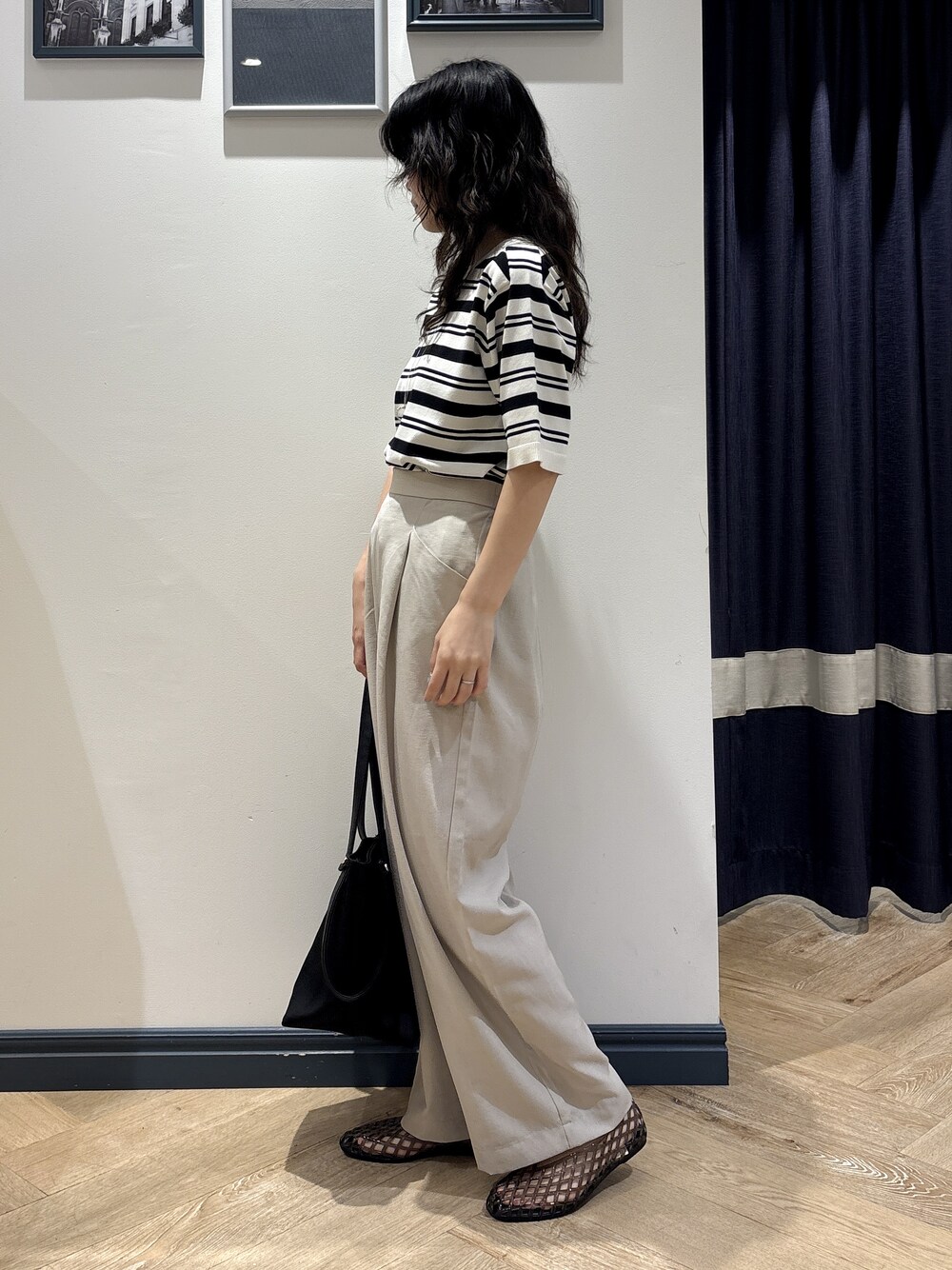 ホワイト系のニット/セーター、ベージュ系のその他パンツ、ブラック系のトートバッグを着用したレディースの夏コーディネートの2枚目の写真
