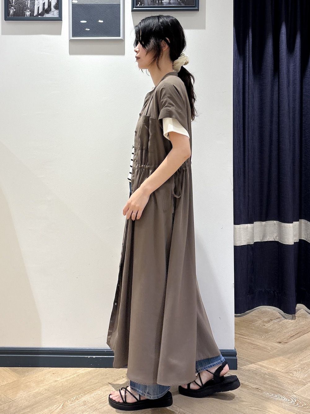 ブラウン系のワンピース、ホワイト系のニット/セーター、ブルー系のデニムパンツを着用したレディースの夏コーディネートの2枚目の写真