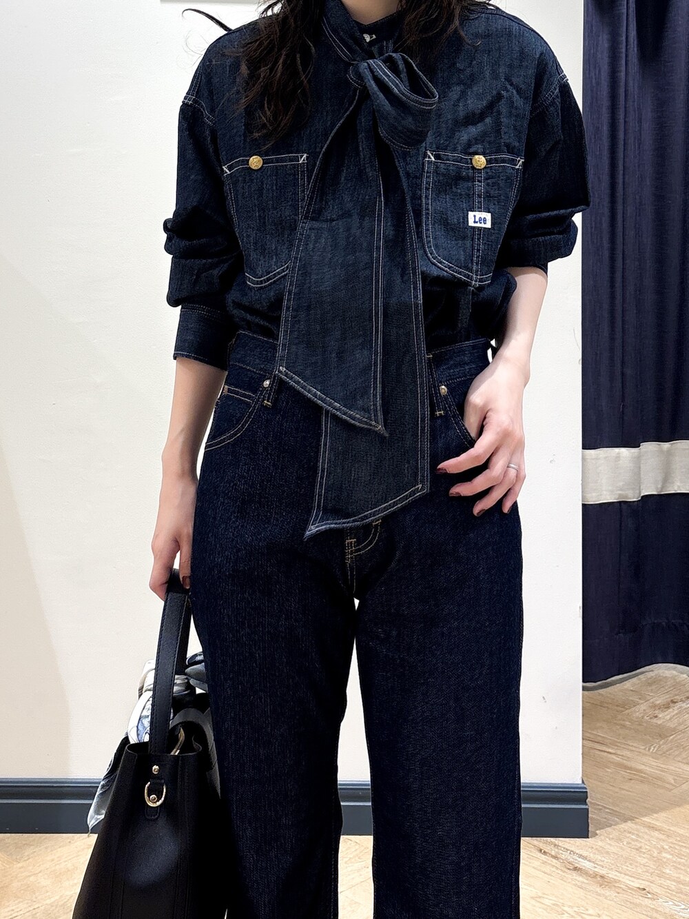 ブルー系のシャツ/ブラウス、ブルー系のデニムパンツ、ブラック系のショルダーバッグを着用したレディースの秋コーディネートの4枚目の写真