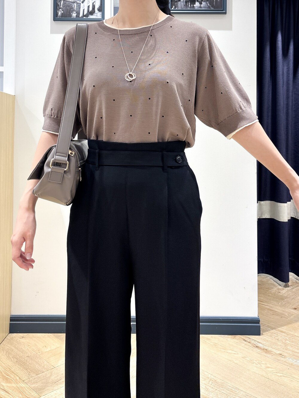 ブラウン系のニット/セーター、ブラック系のその他パンツ、ブラウン系のショルダーバッグを着用したレディースの夏コーディネートの5枚目の写真