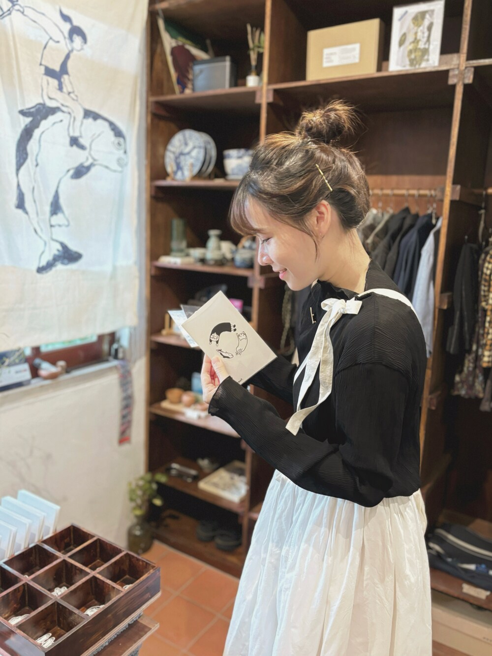 ホワイト系のスカート、ブラウン系のサンダル、ブラック系のスウェットを着用したレディースの秋コーディネートの3枚目の写真