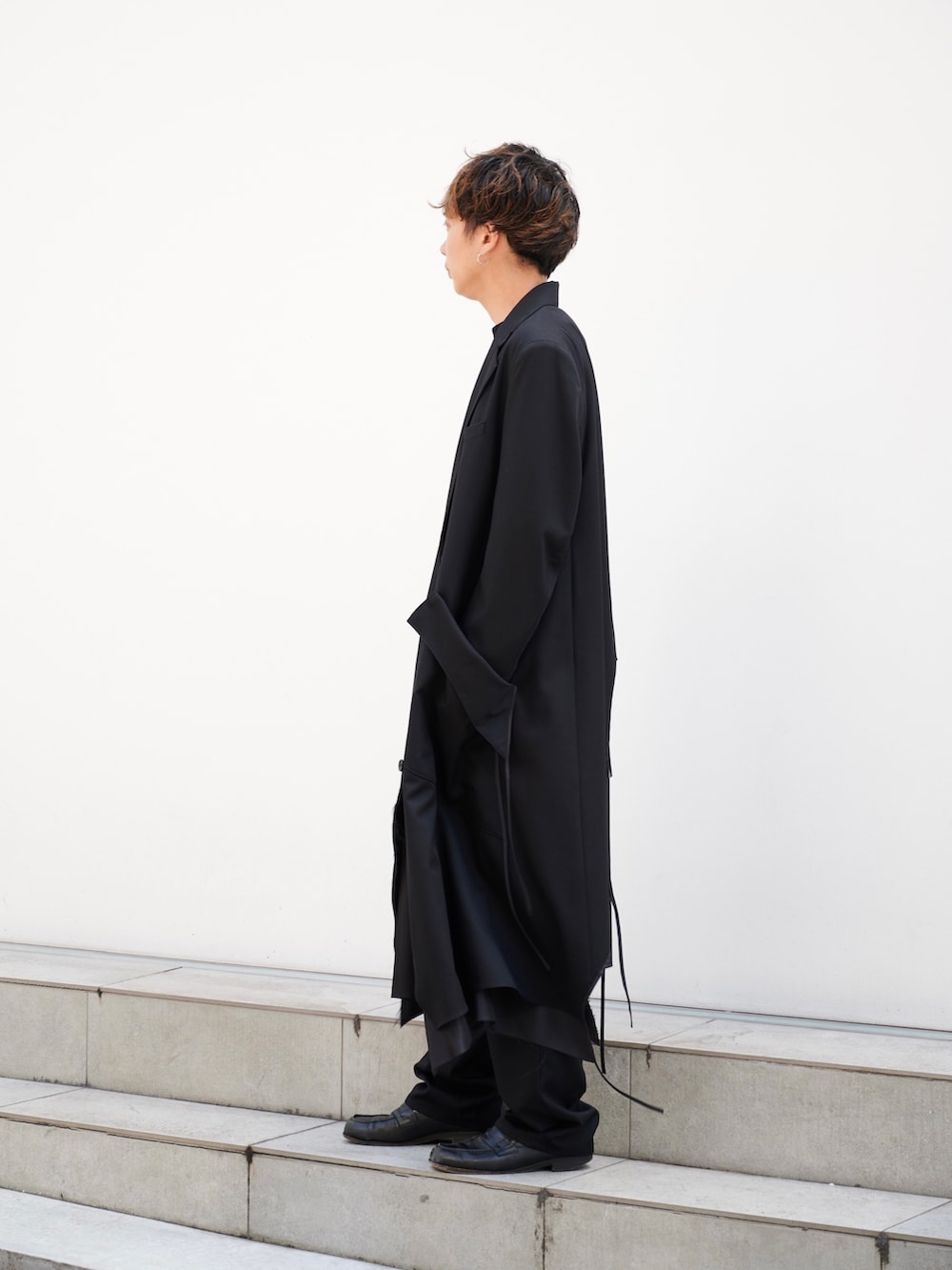 「sulvam、モード、オールブラック、コート、スラックス、STUDIOUS」｜「sulvamの【sulvam/サルバム】GABARDINE PIPING STRAIGHT PANTS（スラックス、ブラック系）」を使った、白鳥巧史さん（メンズ・170cm）の夏コーディネートの2枚目の写真