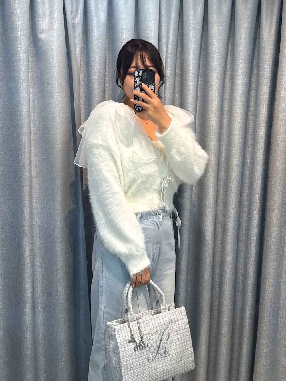 ホワイト系のカーディガン/ボレロ、ブルー系のデニムパンツ、グレー系のトートバッグを着用したレディースの秋コーディネートの2枚目の写真