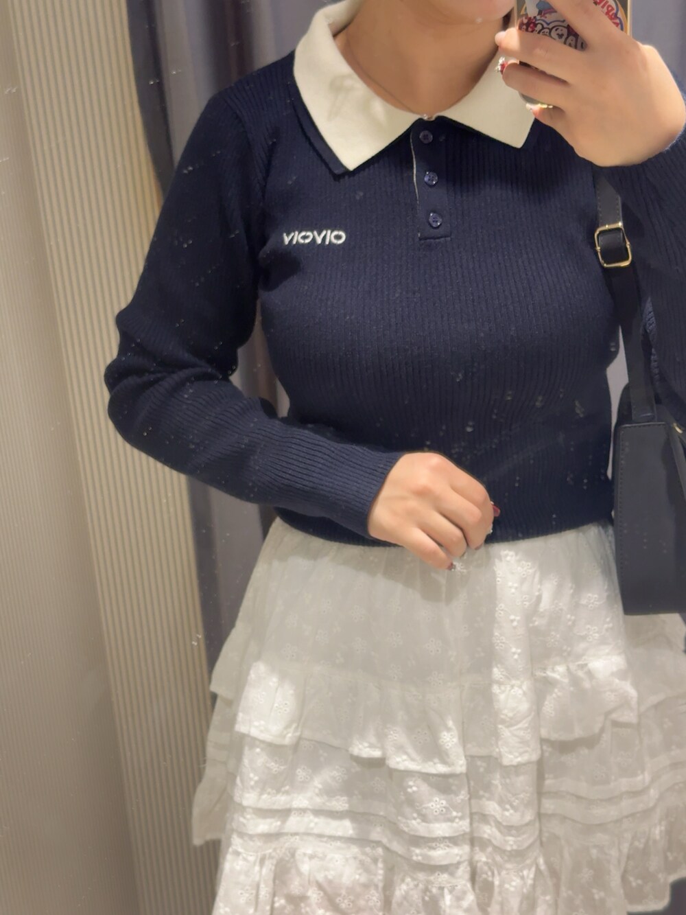 グレー系のニット/セーター、ホワイト系のスカート、ブラック系のショルダーバッグを着用したレディースの冬コーディネートの2枚目の写真