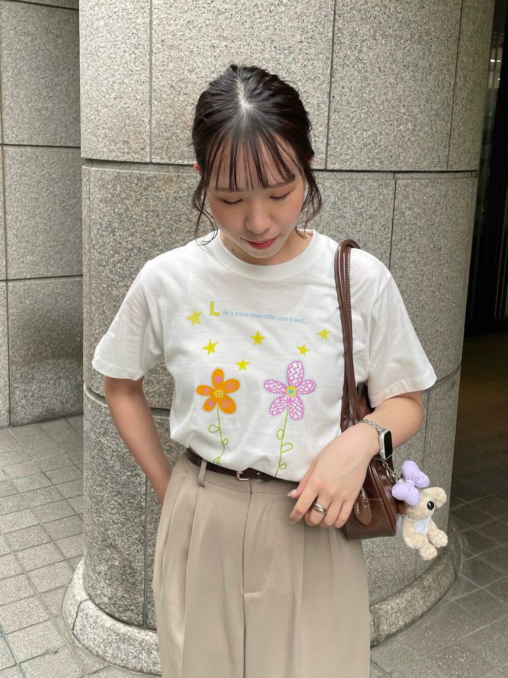 ブラウン系のショルダーバッグ、ホワイト系のTシャツ/カットソー、ベージュ系のスラックスを着用したレディースの夏コーディネートの4枚目の写真