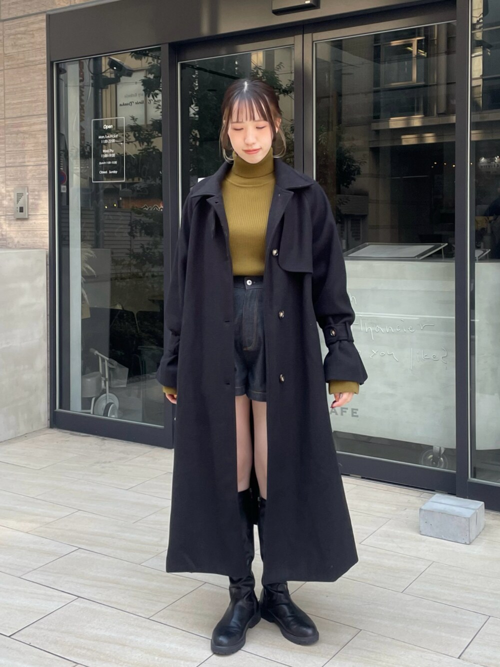 ブラック系のデニムパンツ、グリーン系のニット/セーター、ブラック系のブーツを着用したレディースの冬コーディネートの2枚目の写真