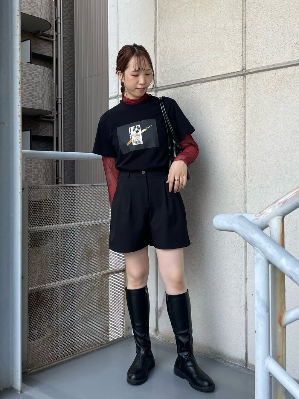 ブラック系のブーツ、ブラック系のショルダーバッグ、ブラック系のTシャツ/カットソーを着用したレディースの秋コーディネートの2枚目の写真