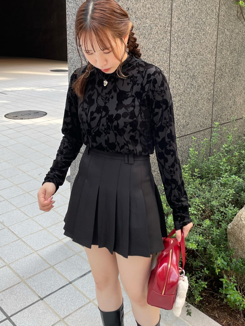 ブラック系のTシャツ/カットソー、ブラック系のスカート、レッド系のハンドバッグを着用したレディースの秋コーディネートの3枚目の写真