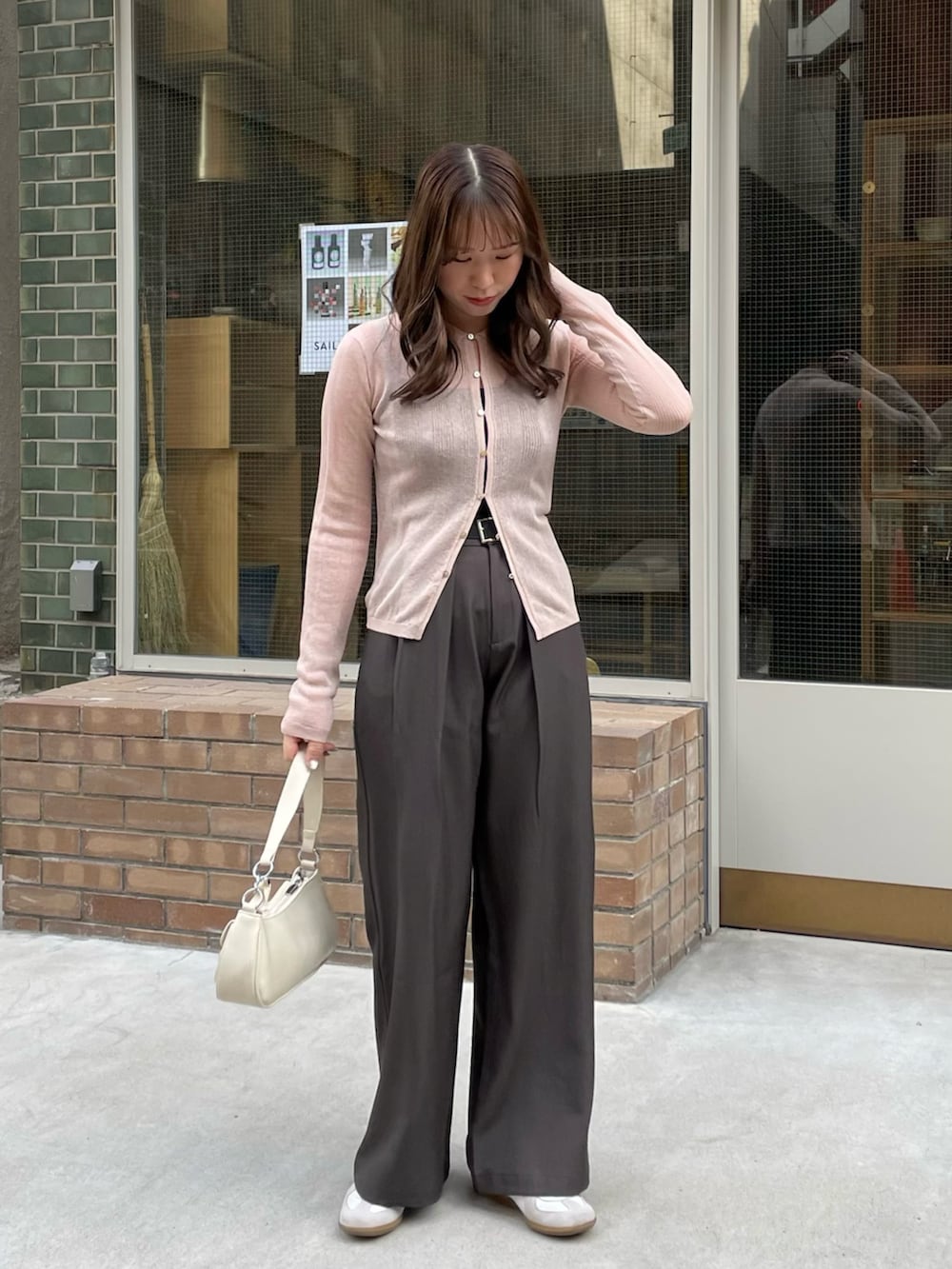 ホワイト系のショルダーバッグ、ピンク系のニット/セーター、グレー系のその他パンツを着用したレディースの春コーディネートの3枚目の写真