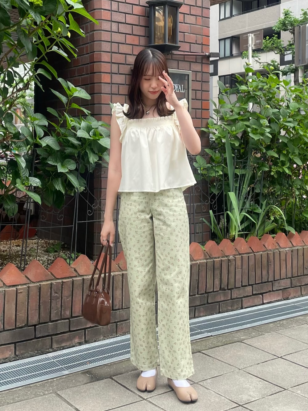 グリーン系のデニムパンツ、ベージュ系のパンプス、イエロー系のキャミソールを着用したレディースの春コーディネートの2枚目の写真