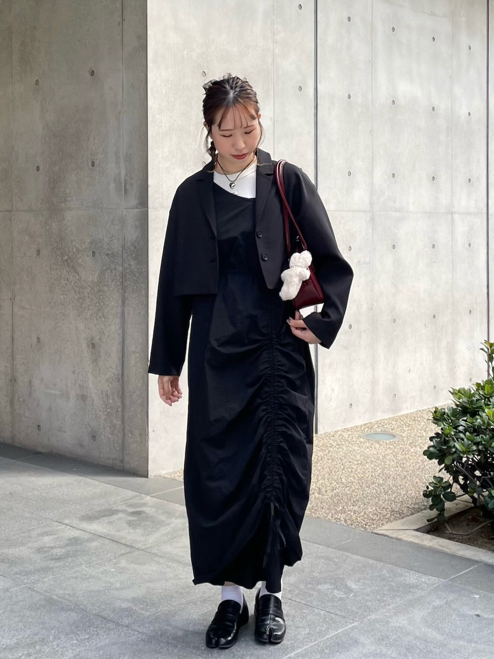 ブラック系のローファー、ブラック系のワンピース、レッド系のショルダーバッグを着用したレディースの秋コーディネートの3枚目の写真