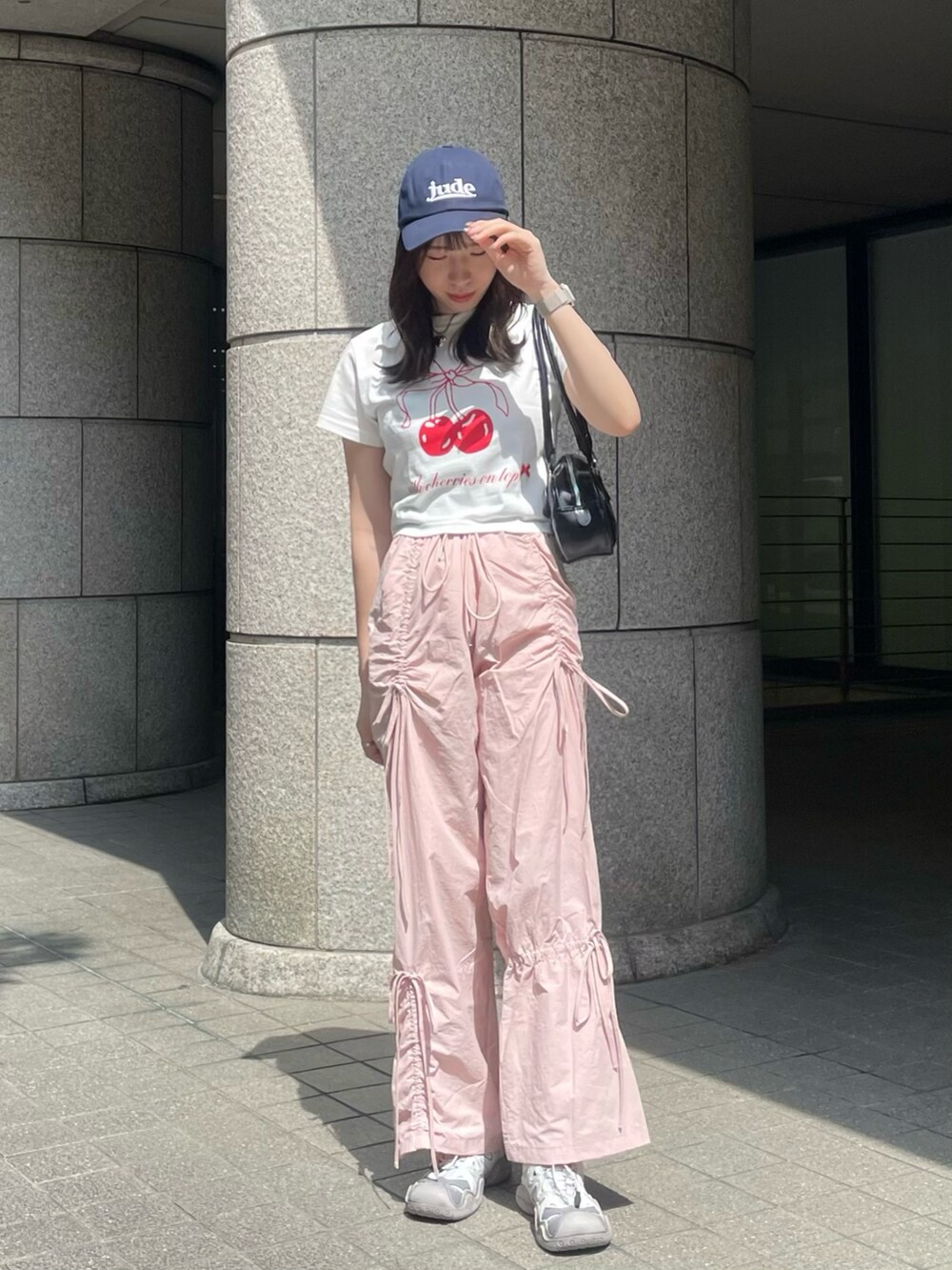 ピンク系のその他パンツ、グレー系のスニーカー、ブラック系のショルダーバッグを着用したレディースの春コーディネートの3枚目の写真