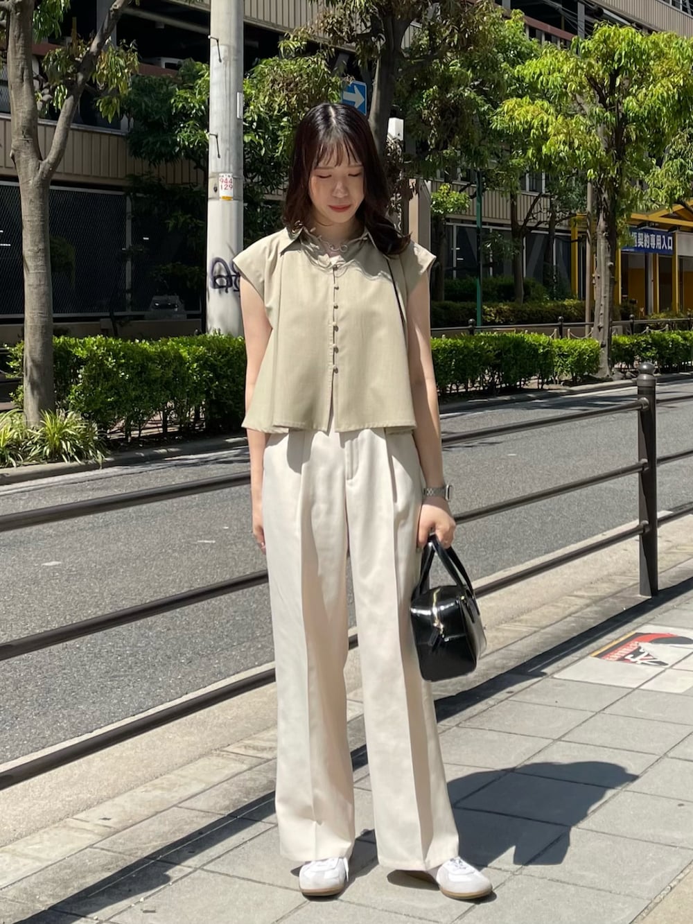 ホワイト系のスラックス、ホワイト系のスニーカー、ベージュ系のシャツ/ブラウスを着用したレディースの夏コーディネートの2枚目の写真