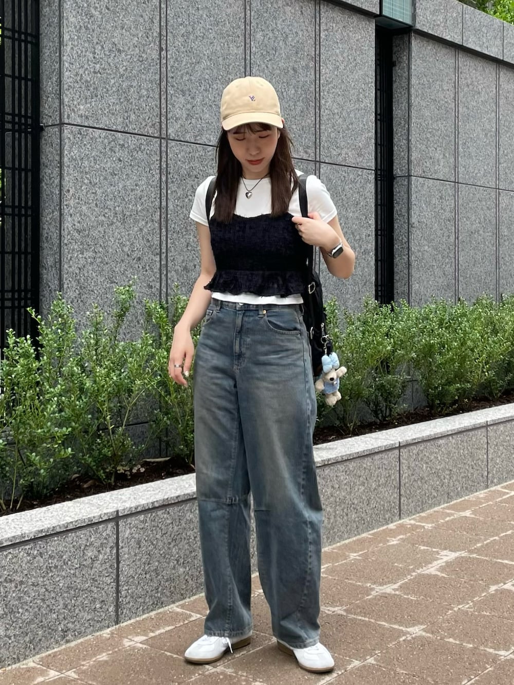 ブラック系のキャミソール、ホワイト系のTシャツ/カットソー、ブルー系のデニムパンツを着用したレディースの夏コーディネートの2枚目の写真