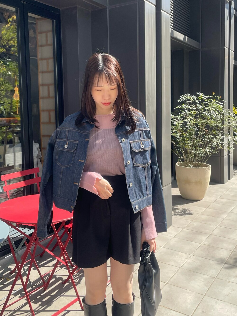 ブラック系のバッグ、ブラック系のブーツ、ブラック系のパンツを着用したレディースの春コーディネートの3枚目の写真