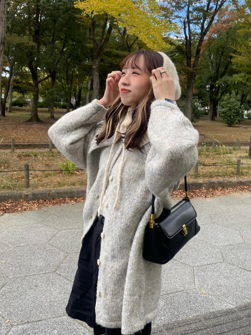 ブラック系のブーツ、グレー系のニット/セーター、ブラック系のパンツを着用したレディースの秋コーディネートの4枚目の写真
