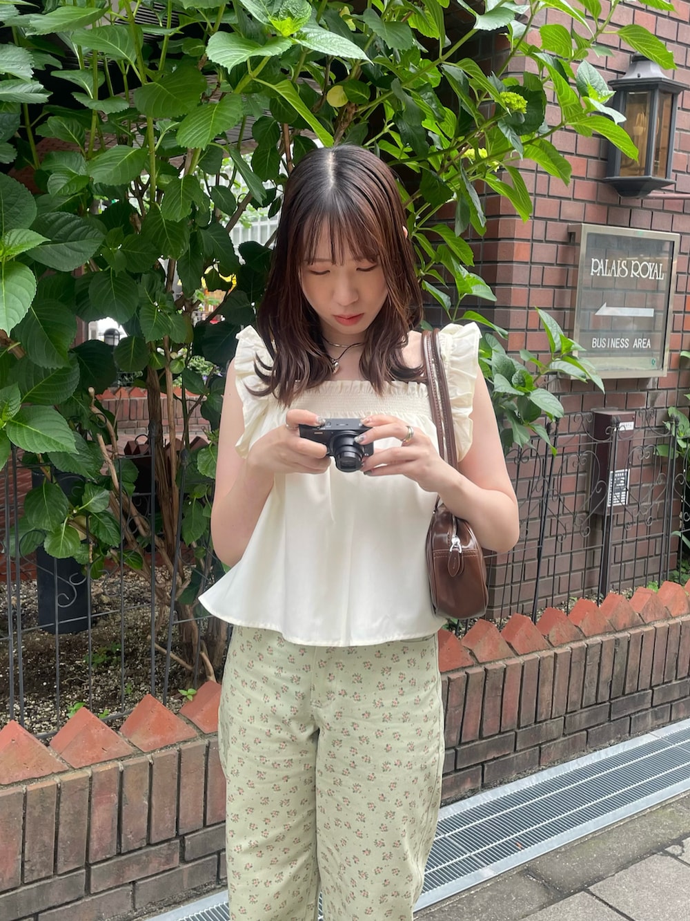 グリーン系のデニムパンツ、ベージュ系のパンプス、イエロー系のキャミソールを着用したレディースの春コーディネートの3枚目の写真