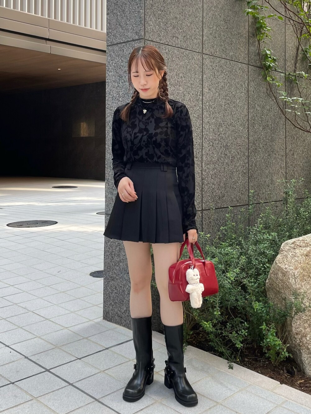 ブラック系のTシャツ/カットソー、ブラック系のスカート、レッド系のハンドバッグを着用したレディースの秋コーディネートの2枚目の写真