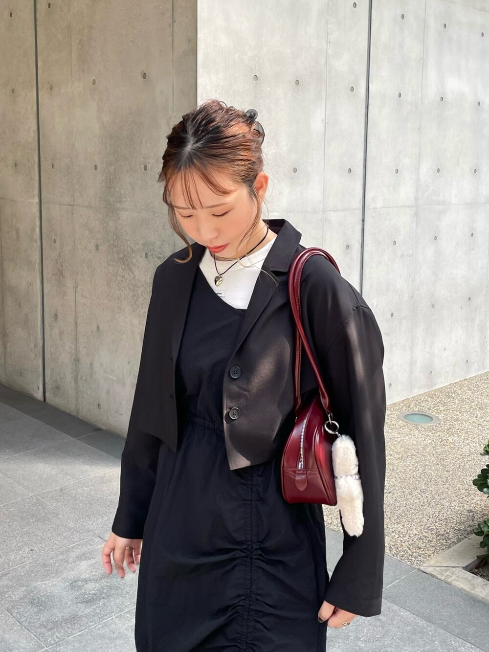 ブラック系のローファー、ブラック系のワンピース、レッド系のショルダーバッグを着用したレディースの秋コーディネートの4枚目の写真