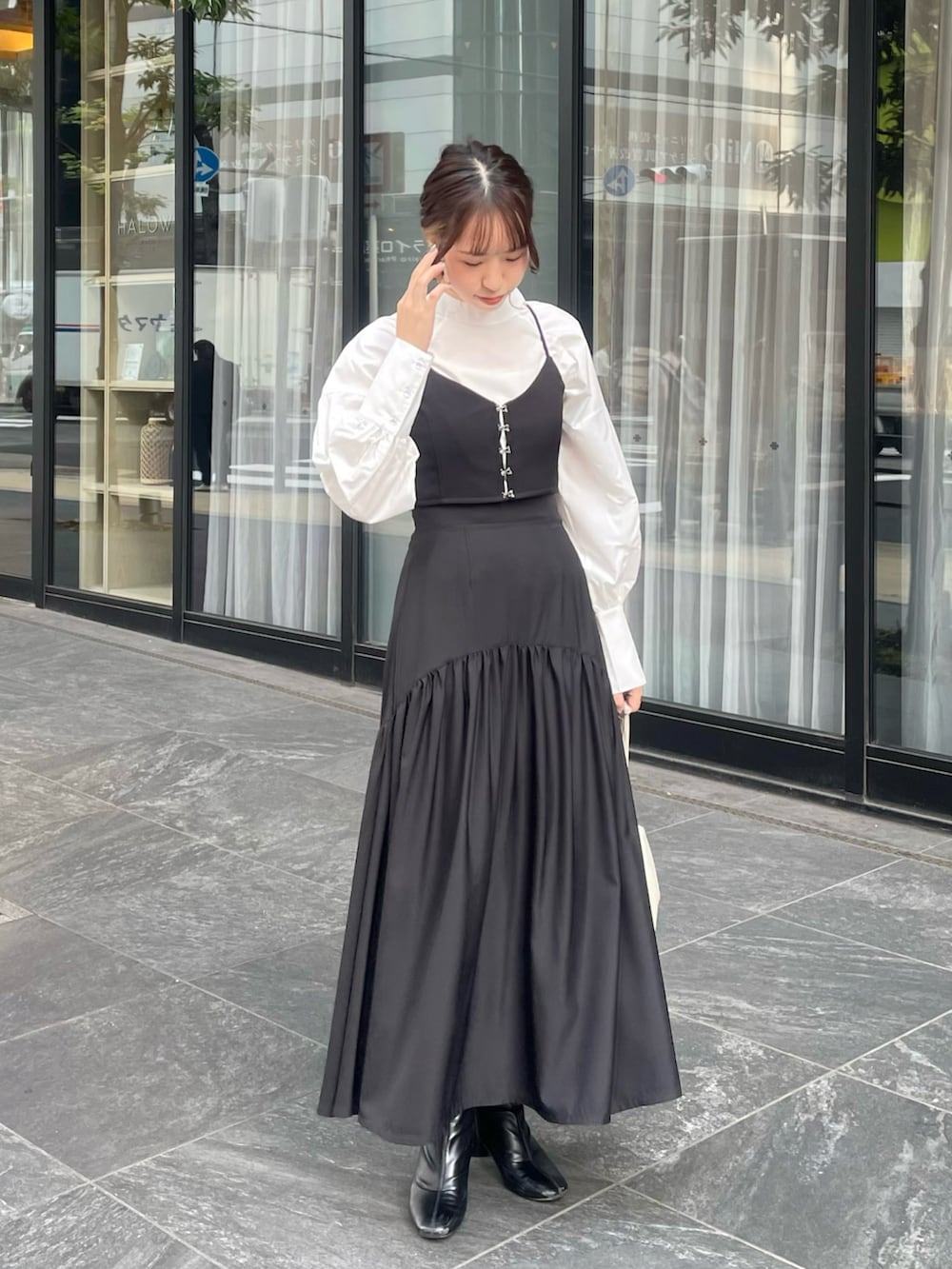 ブラック系のブーツ、ブラック系のスカート、ブラック系のドレスを着用したレディースの秋コーディネートの3枚目の写真