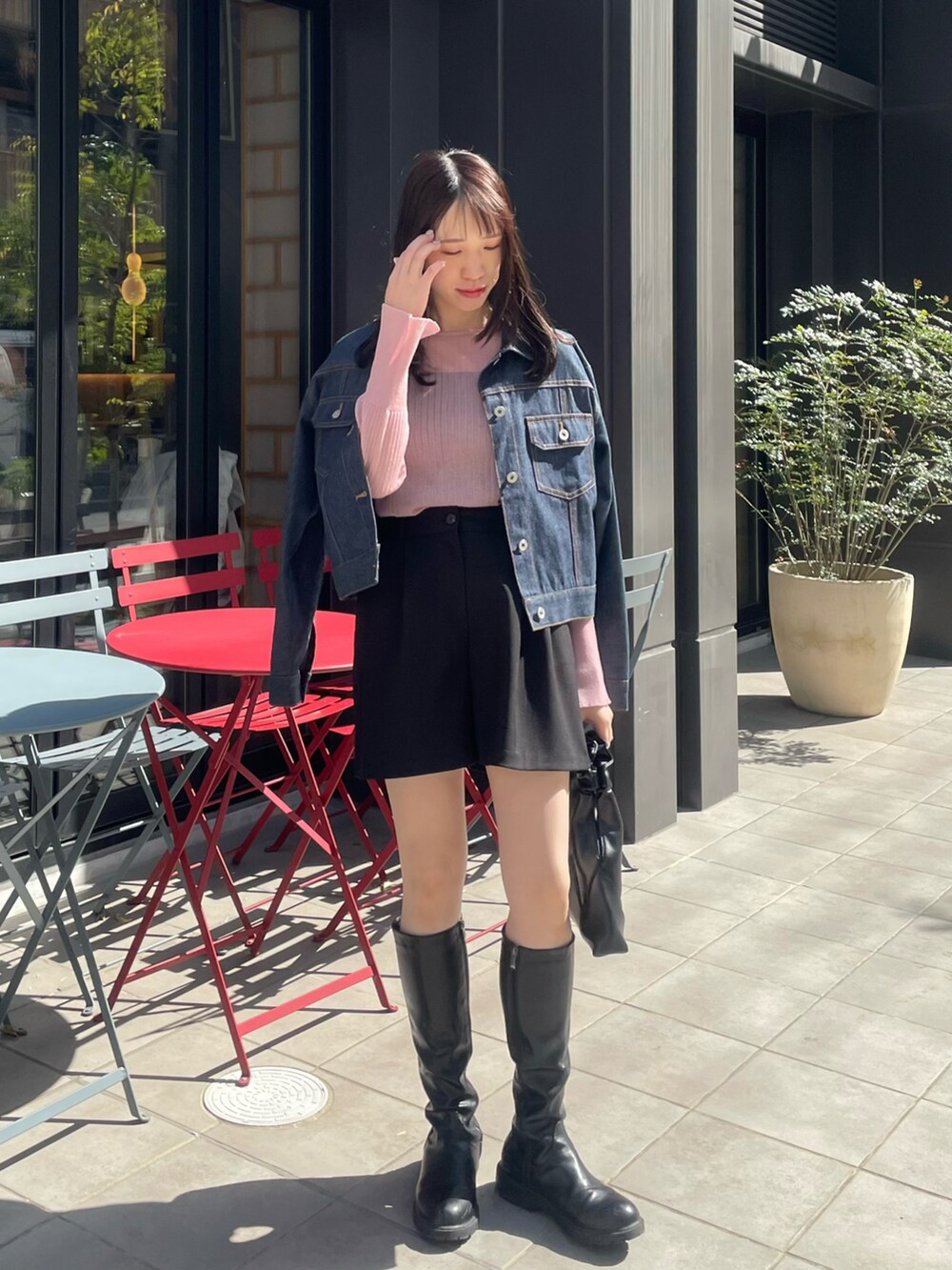 ブラック系のバッグ、ブラック系のブーツ、ブラック系のパンツを着用したレディースの春コーディネートの2枚目の写真