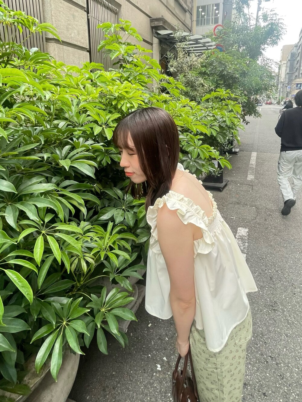 グリーン系のデニムパンツ、ベージュ系のパンプス、イエロー系のキャミソールを着用したレディースの春コーディネートの4枚目の写真