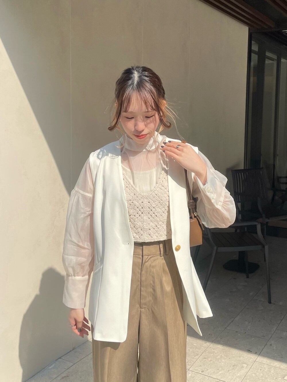 ブラック系のローファー、ホワイト系のシャツ/ブラウス、ベージュ系のベストを着用したレディースの春コーディネートの3枚目の写真