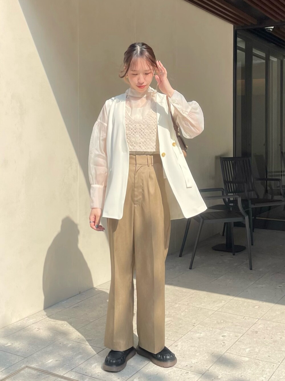 ブラック系のローファー、ホワイト系のシャツ/ブラウス、ベージュ系のベストを着用したレディースの春コーディネートの2枚目の写真