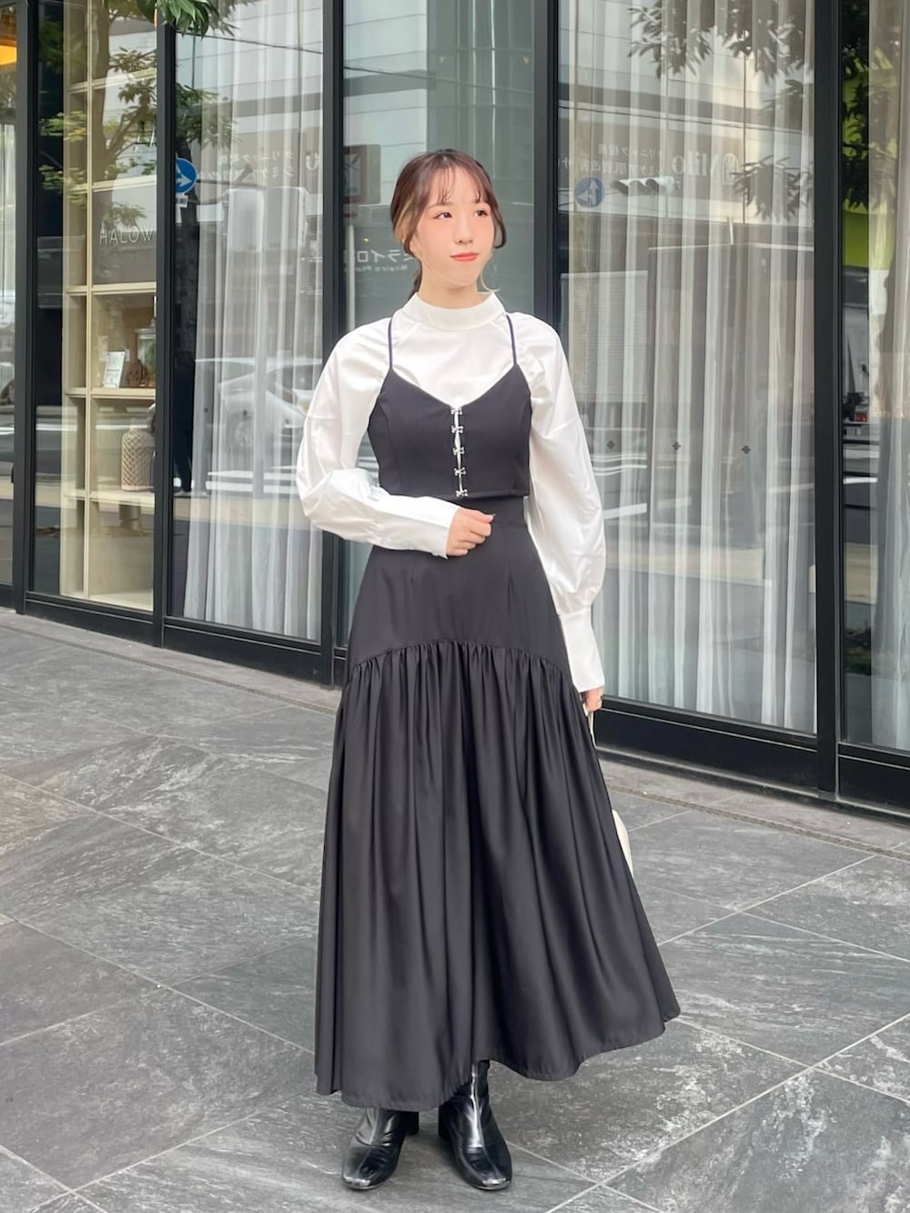 ブラック系のブーツ、ブラック系のスカート、ブラック系のドレスを着用したレディースの秋コーディネートの2枚目の写真