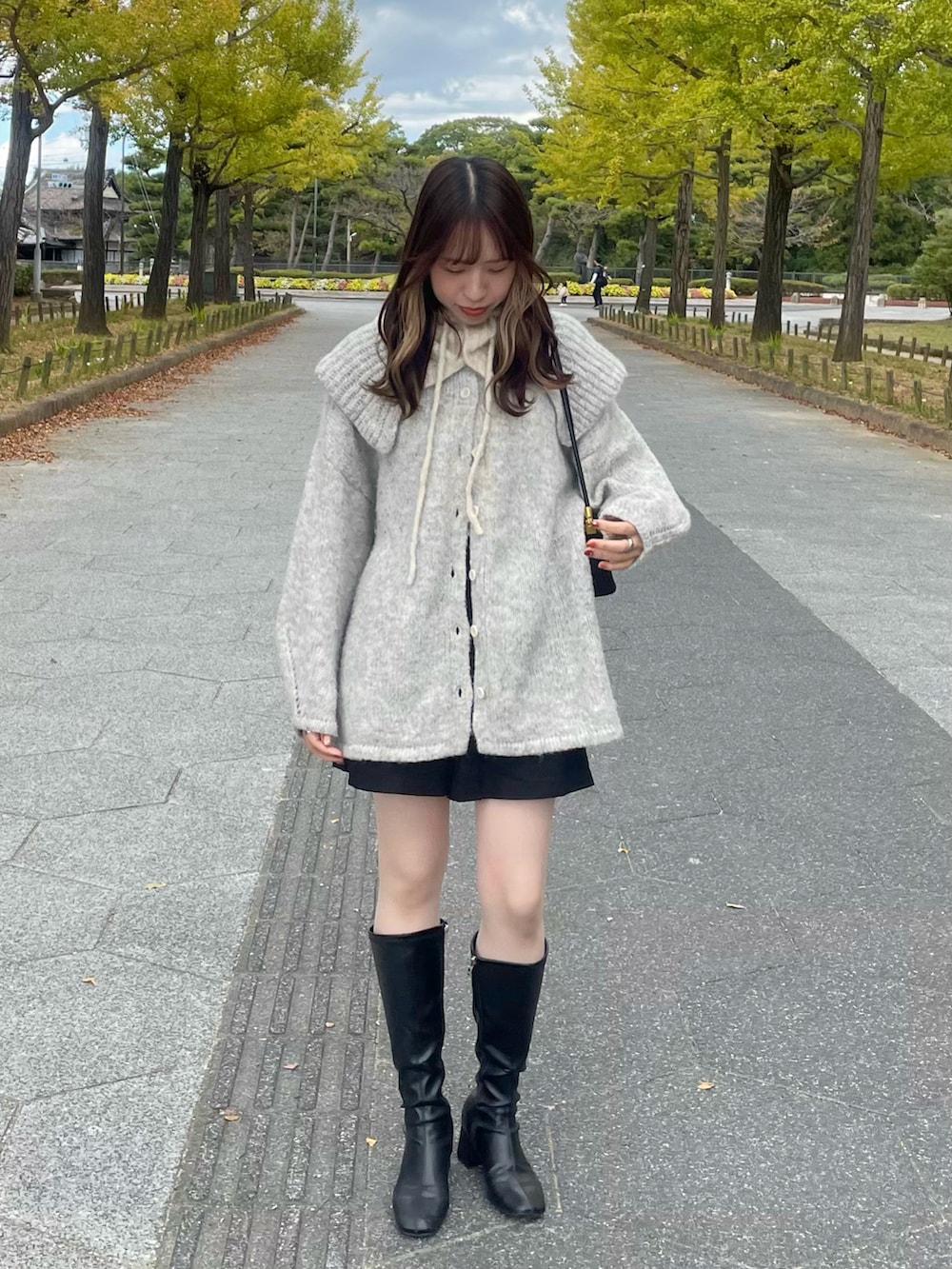 ブラック系のブーツ、グレー系のニット/セーター、ブラック系のパンツを着用したレディースの秋コーディネートの2枚目の写真