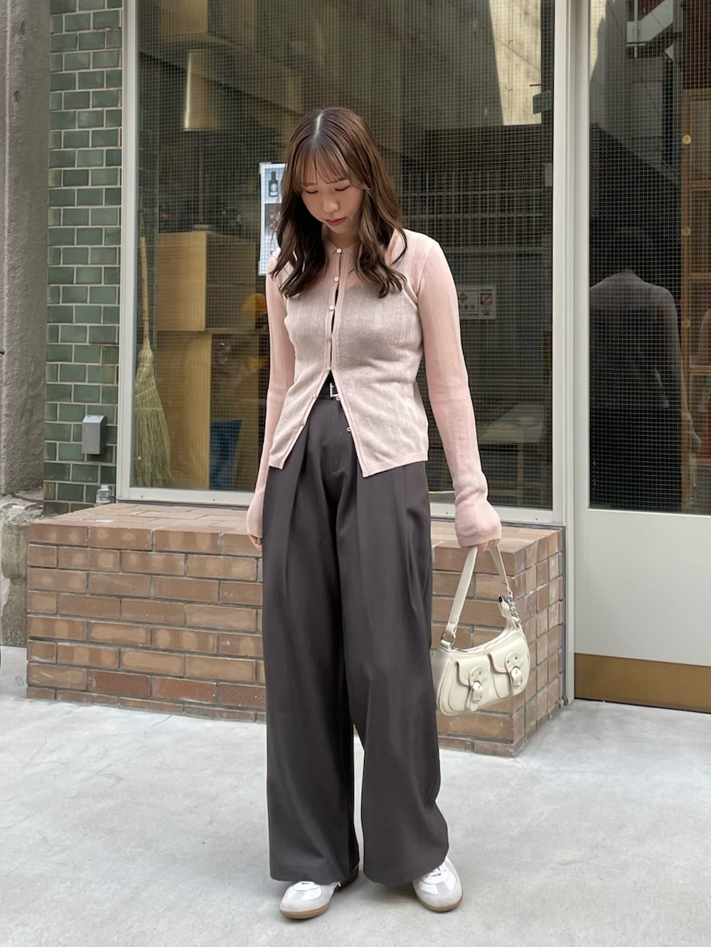 ホワイト系のショルダーバッグ、ピンク系のニット/セーター、グレー系のその他パンツを着用したレディースの春コーディネートの2枚目の写真