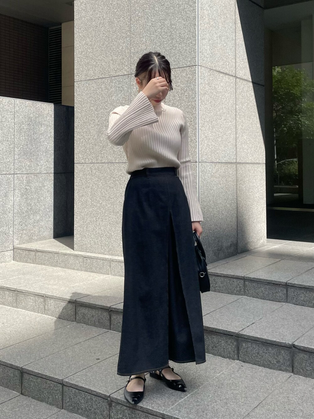 ホワイト系のニット/セーター、ブラック系のスカート、ブラック系のその他シューズを着用したレディースの秋コーディネートの2枚目の写真