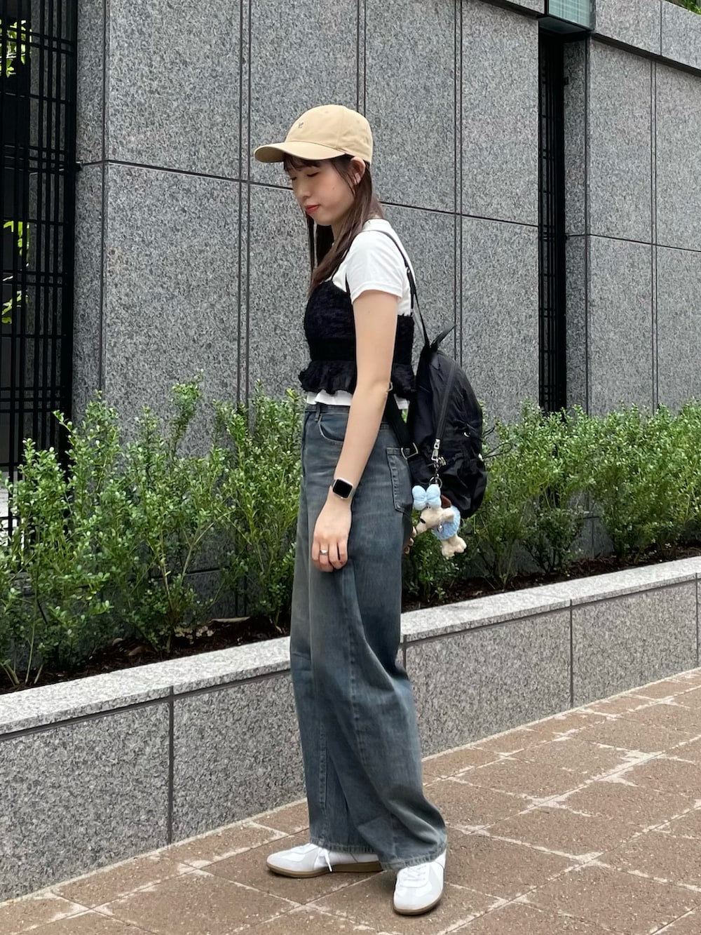 ブラック系のキャミソール、ホワイト系のTシャツ/カットソー、ブルー系のデニムパンツを着用したレディースの夏コーディネートの3枚目の写真