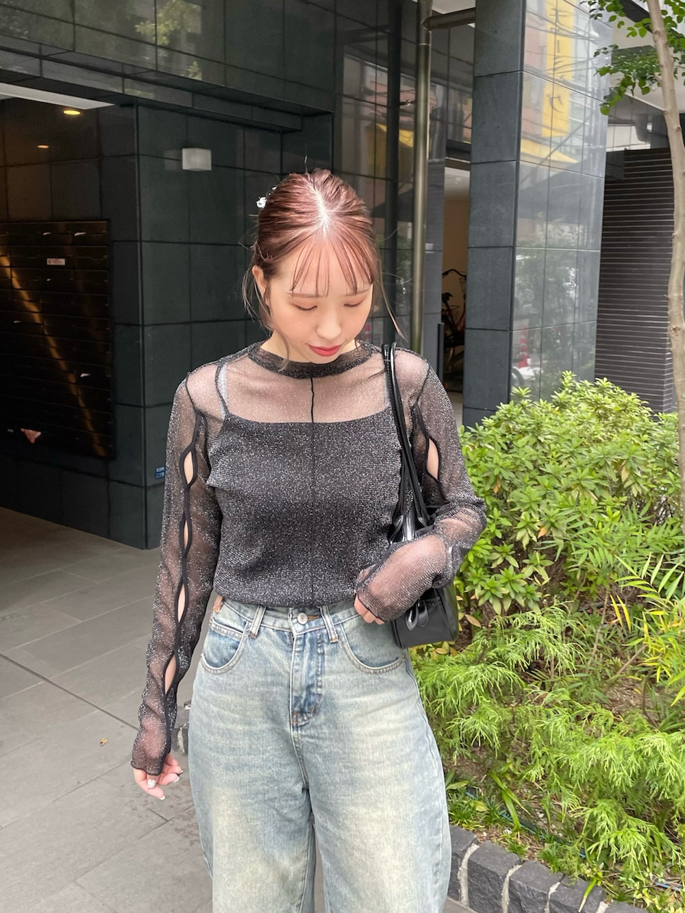 グリーン系のデニムパンツ、ブラック系のスニーカー、ブラック系のショルダーバッグを着用したレディースの秋コーディネートの3枚目の写真