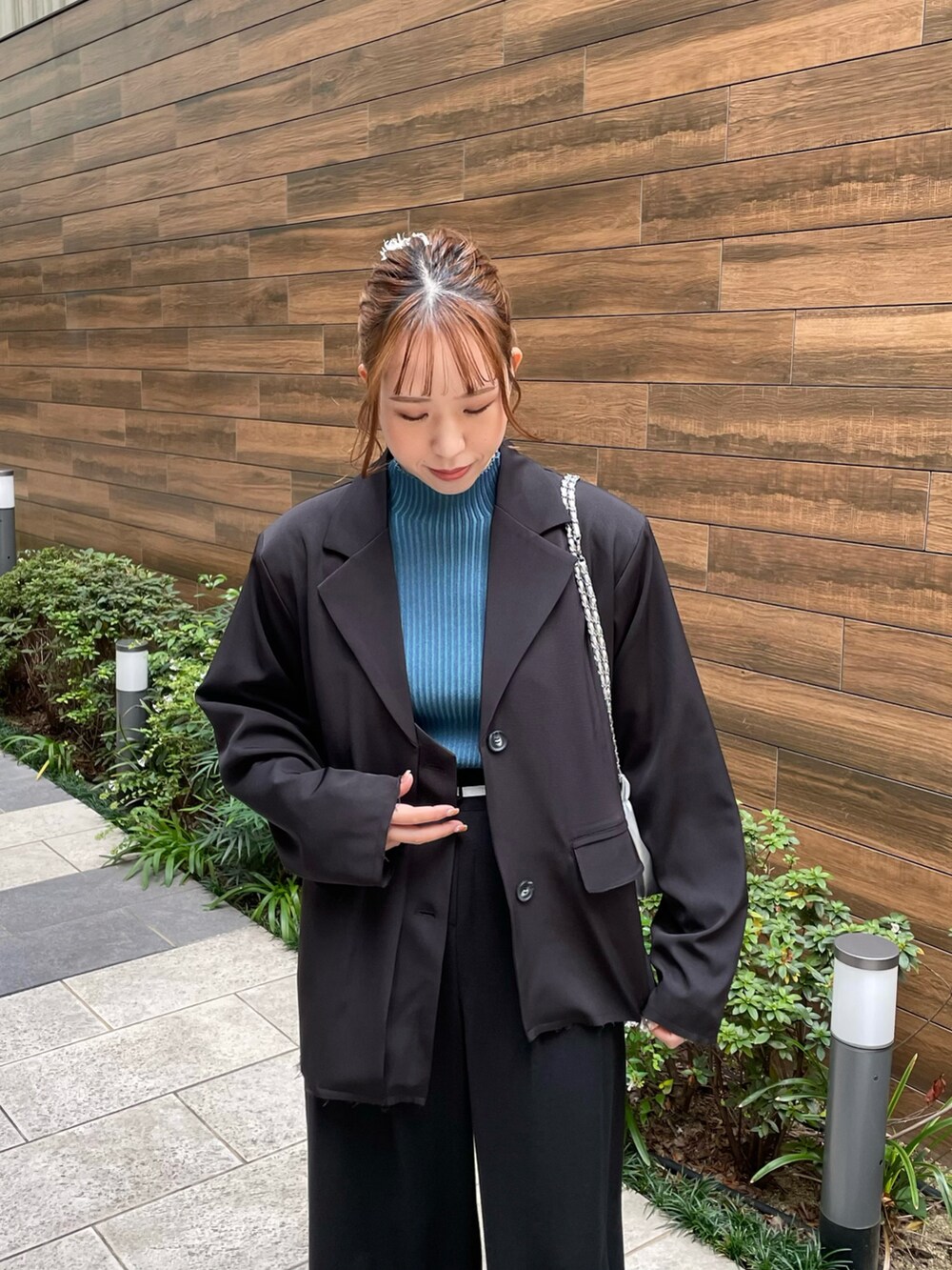 ブルー系のニット/セーター、シルバー系のショルダーバッグ、ブラック系のスラックスを着用したレディースの秋コーディネートの3枚目の写真