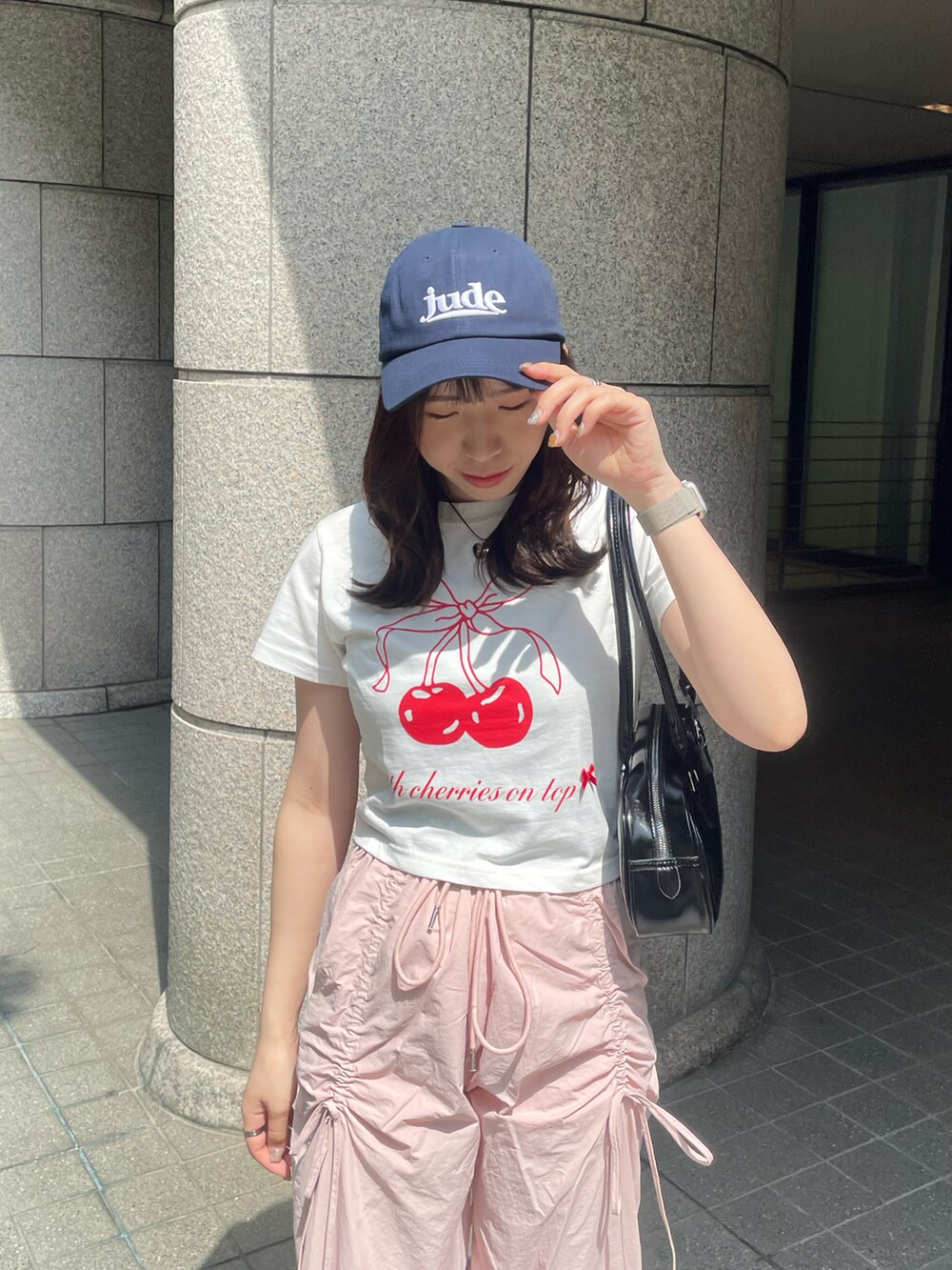 ピンク系のその他パンツ、グレー系のスニーカー、ブラック系のショルダーバッグを着用したレディースの春コーディネートの4枚目の写真