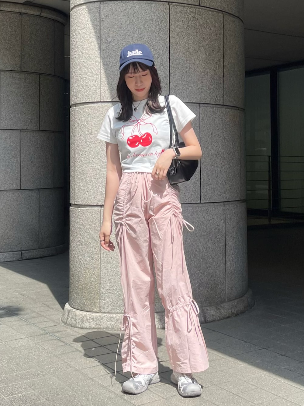 ピンク系のその他パンツ、グレー系のスニーカー、ブラック系のショルダーバッグを着用したレディースの春コーディネートの2枚目の写真