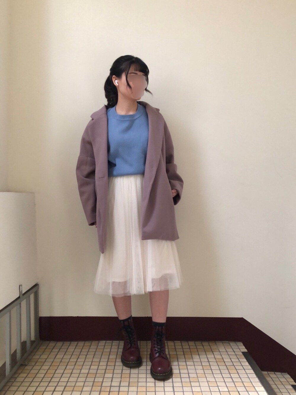 ブラウン系のニット/セーター、ベージュ系のスカート、ブラック系のブーツを着用したレディースの冬コーディネートの2枚目の写真