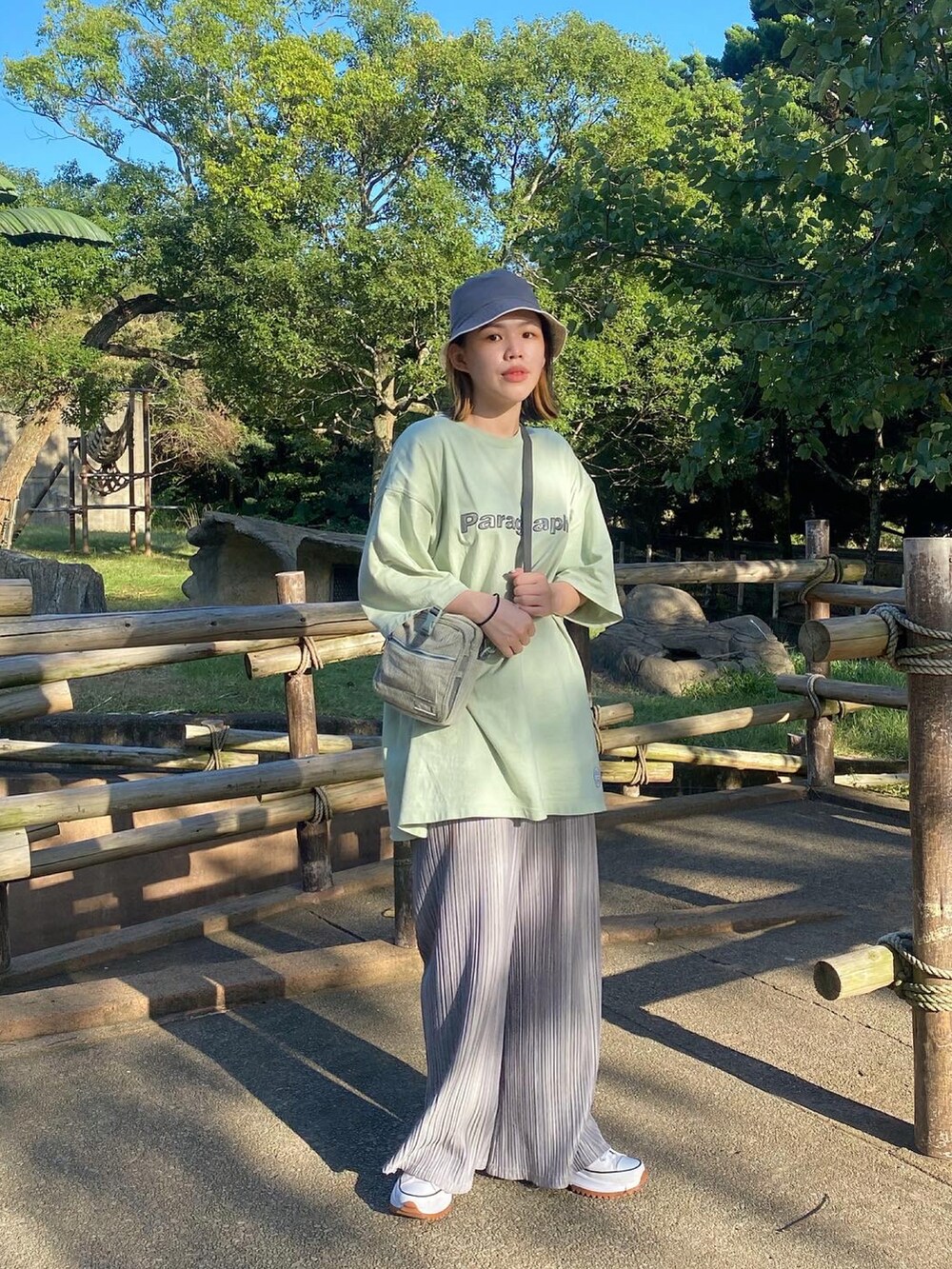 ホワイト系のスニーカー、ホワイト系のTシャツ/カットソー、ブルー系のショルダーバッグを着用したレディースの春コーディネートの2枚目の写真