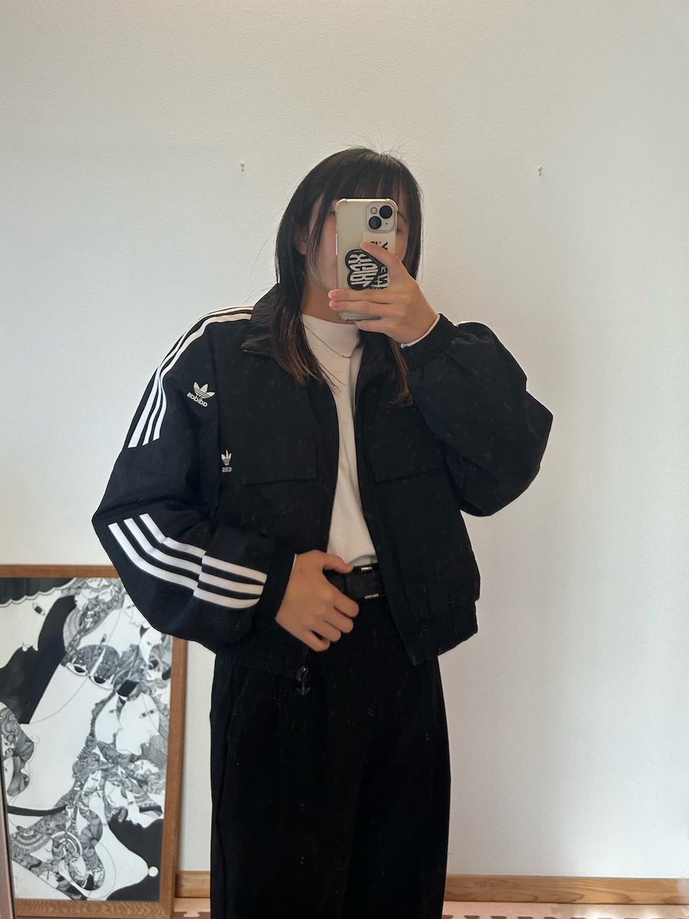 ブラック系のナイロンジャケット、ブラック系のスラックス、ホワイト系のTシャツ/カットソーを着用したレディースの冬コーディネートの2枚目の写真