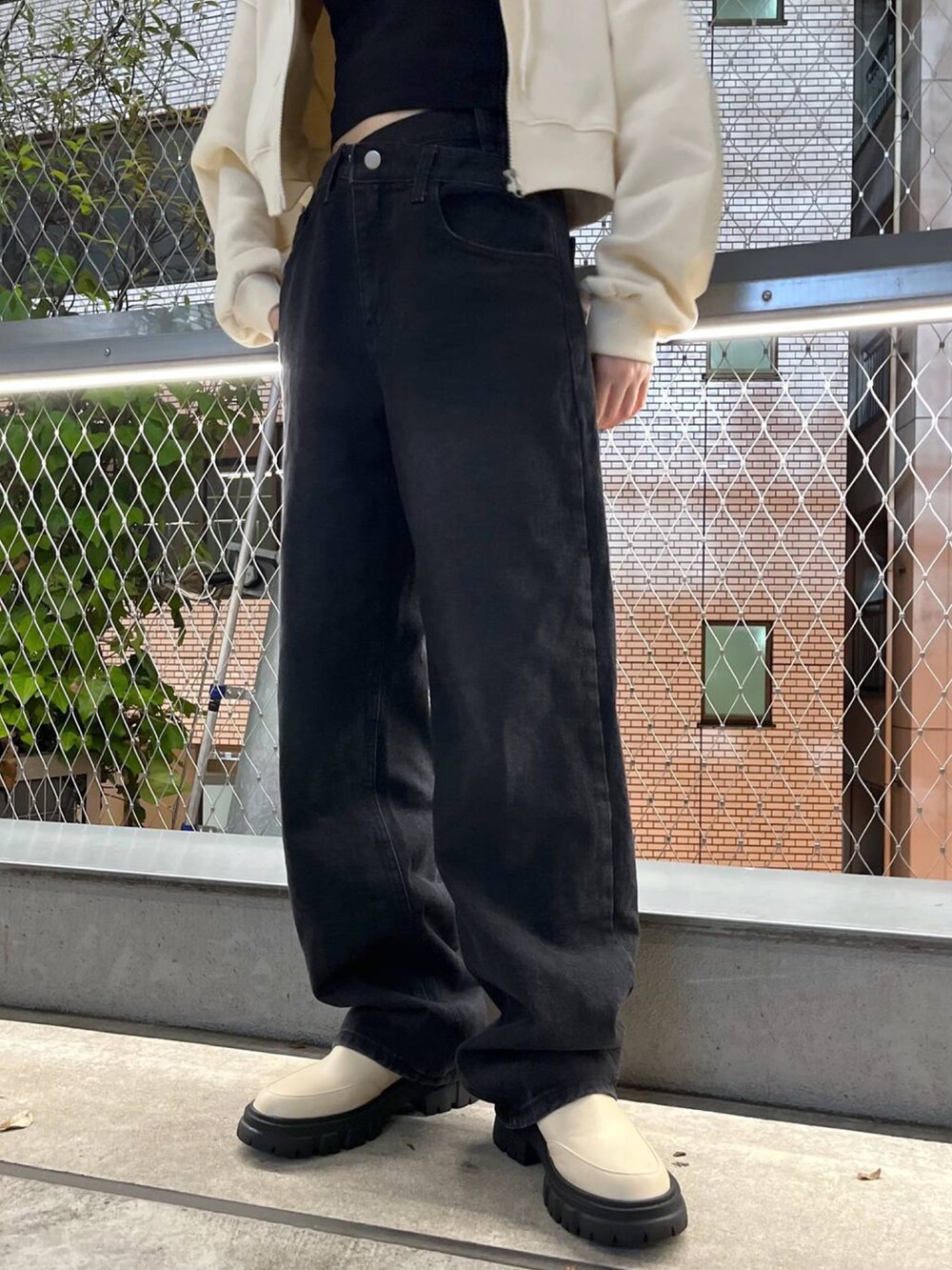 ベージュ系のパーカー、ブラック系のデニムパンツ、ブラック系のインナーウェア/肌着を着用したレディースの秋コーディネートの2枚目の写真