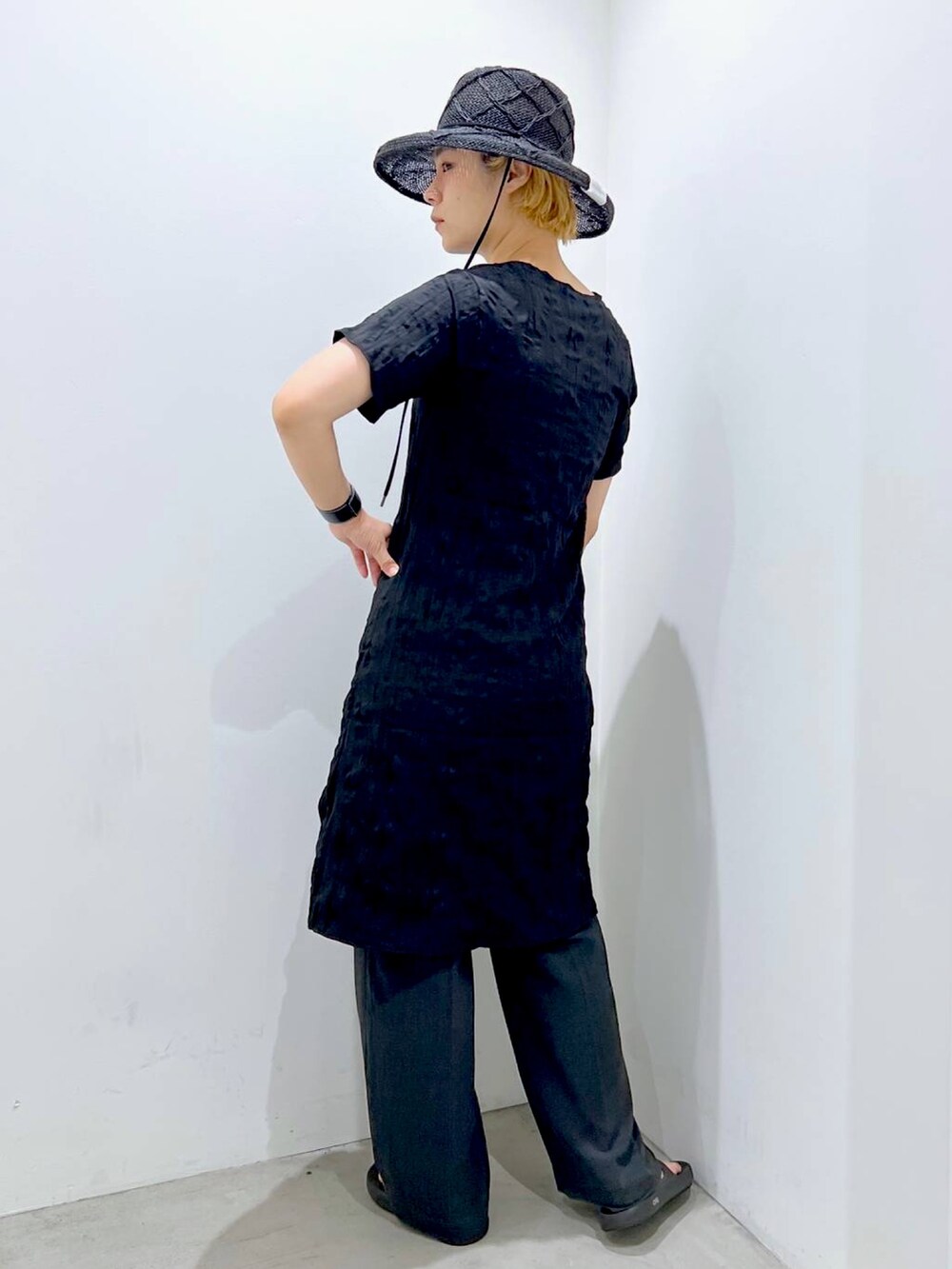 ブラック系のワンピース、グレー系のスラックスを着用したレディースの夏コーディネートの3枚目の写真